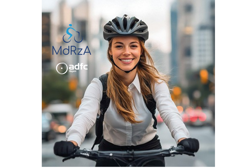 Mit dem Rad zur Arbeit 2026 Frau auf Fahrrad mit langen Haaren, schwarzem Fahrradhelm in städtischer Silhouette radelt dem Betrachter entgegen