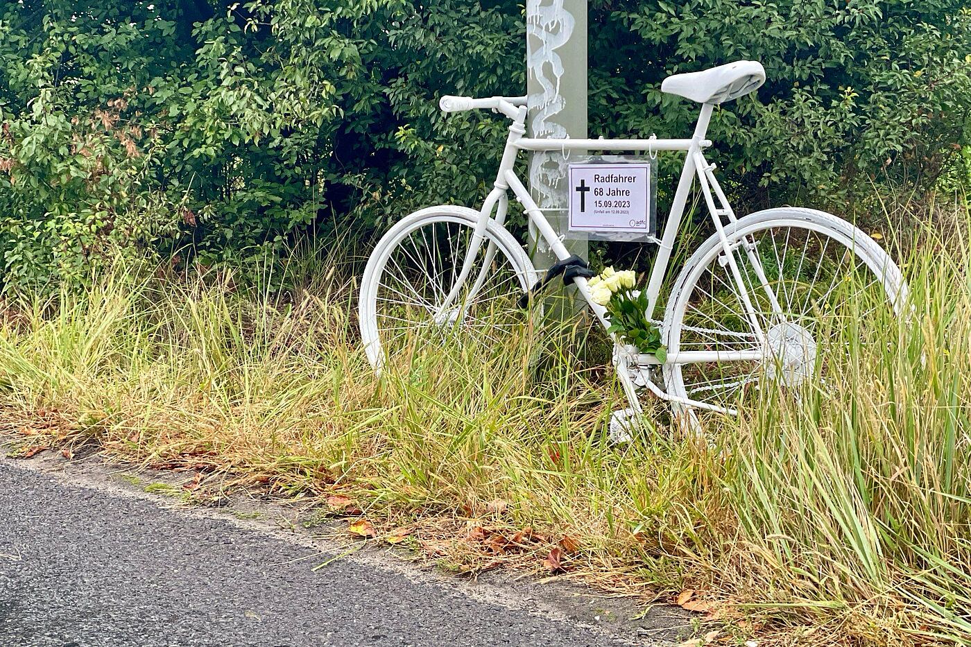 Geisterrad Mahnwache am 22. September 2023 ein weißes Geisterrad mit Schild und weißen Rosen am Straßenrand