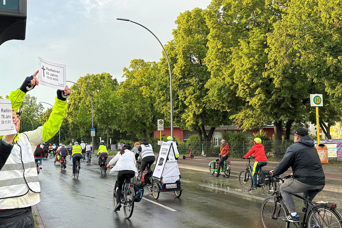 Ride of Silence 2026 Buckower Damm Menschen halten zwei weiße Gedenkschilder bei Fahrraddemonstration in die Luft