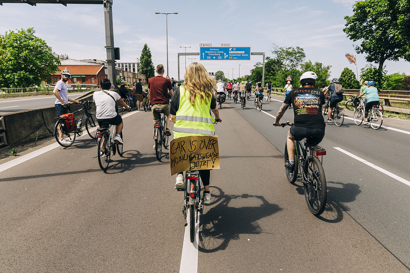 Sternfahrt 2025 Radfahrende auf der Autobahn bei der Sternfahrt. Frau mit Warnweste und "Car is over" Schild