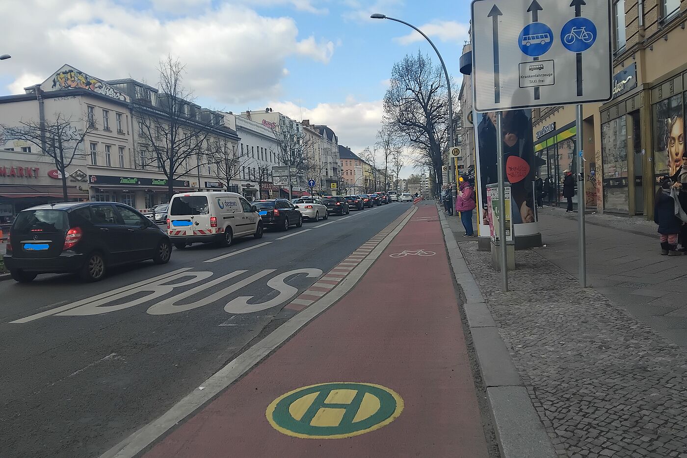 Markiertes Haltestellenkap mit Radverkehrsführung, für Fahrgäste nicht barrierefrei Das Bild zeigt eine Aufteilung des Straßenraums von links nach rechts in eine Fahrspur für den Kfz-Verkehr, ein Bussonderfahrstreifen, ein Radfahrstreifen und daneben der Wartebereich einer Haltestelle.