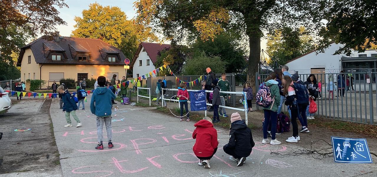 Kinder spielen in der Waplitzer Straße vor dem Eingang zum Gelände der Franz-Carl-Achard-Grundschule