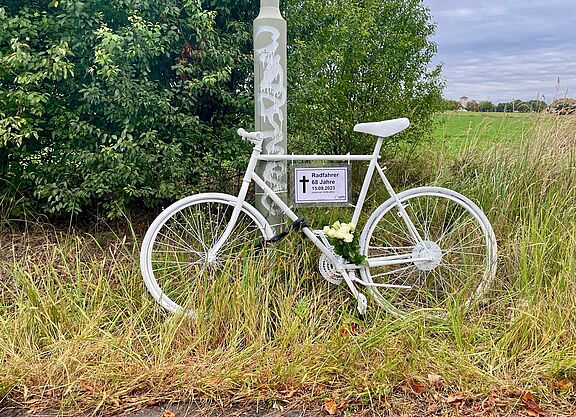 Geisterrad 22. September 2023 weißes Geisterrad mit Schild und weißen Rosen am Wegrand