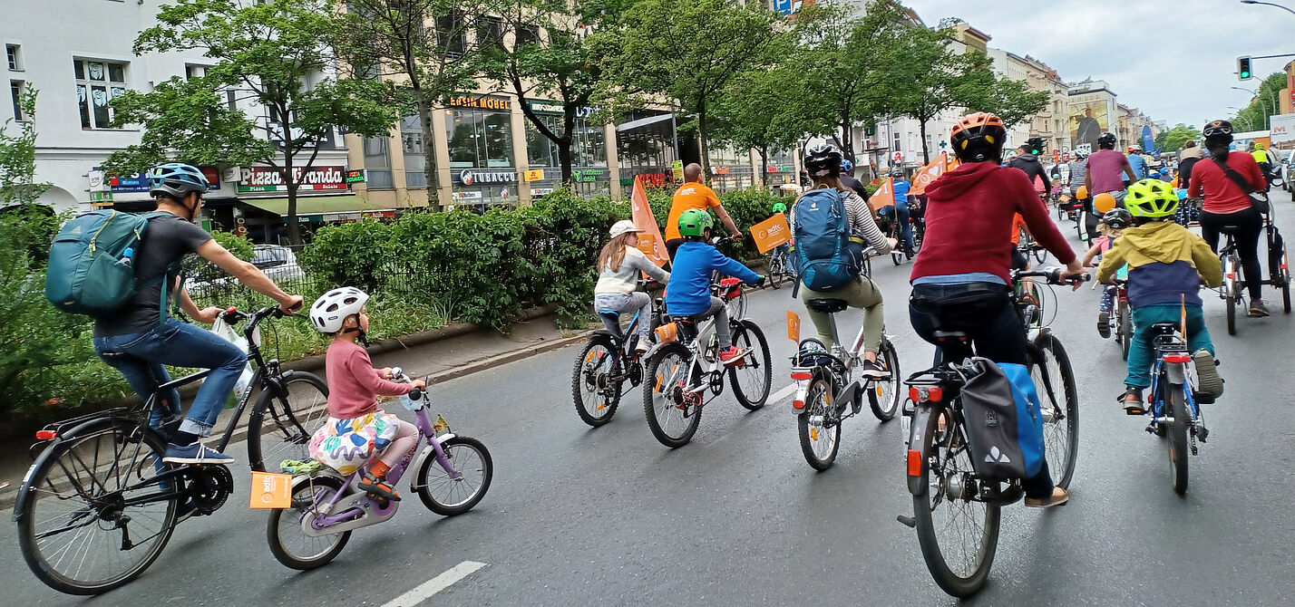 Glückliche Kinder radeln bei der KidicalMass über große Straßen Glückliche Kinder radeln bei der KidicalMass über große Straßen