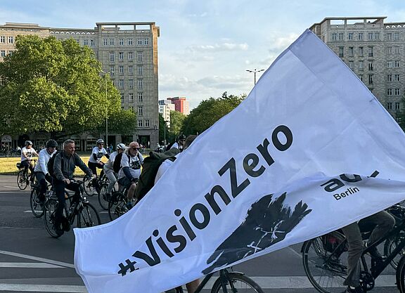 Ride of Silence 2025 weiße Vision Zero Fahne weht vor Radfahrenden