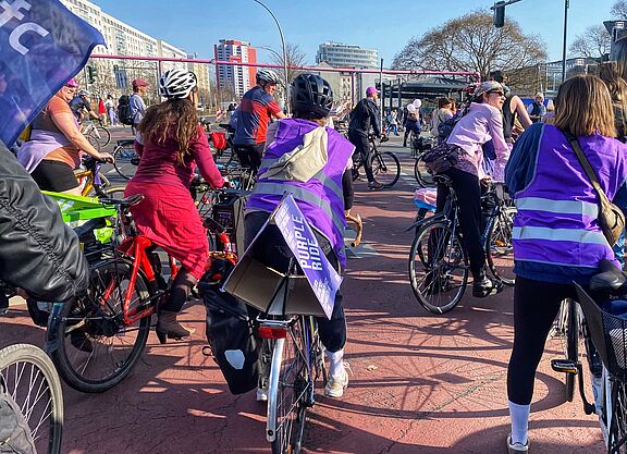 Der ADFC Berlin nimmt am Purple Ride teil. Beim Purple Ride am 08.03.2025 sind mehrere Teilnehmerinnen zu sehen, und auch eine Flagge des ADFC Berlin
