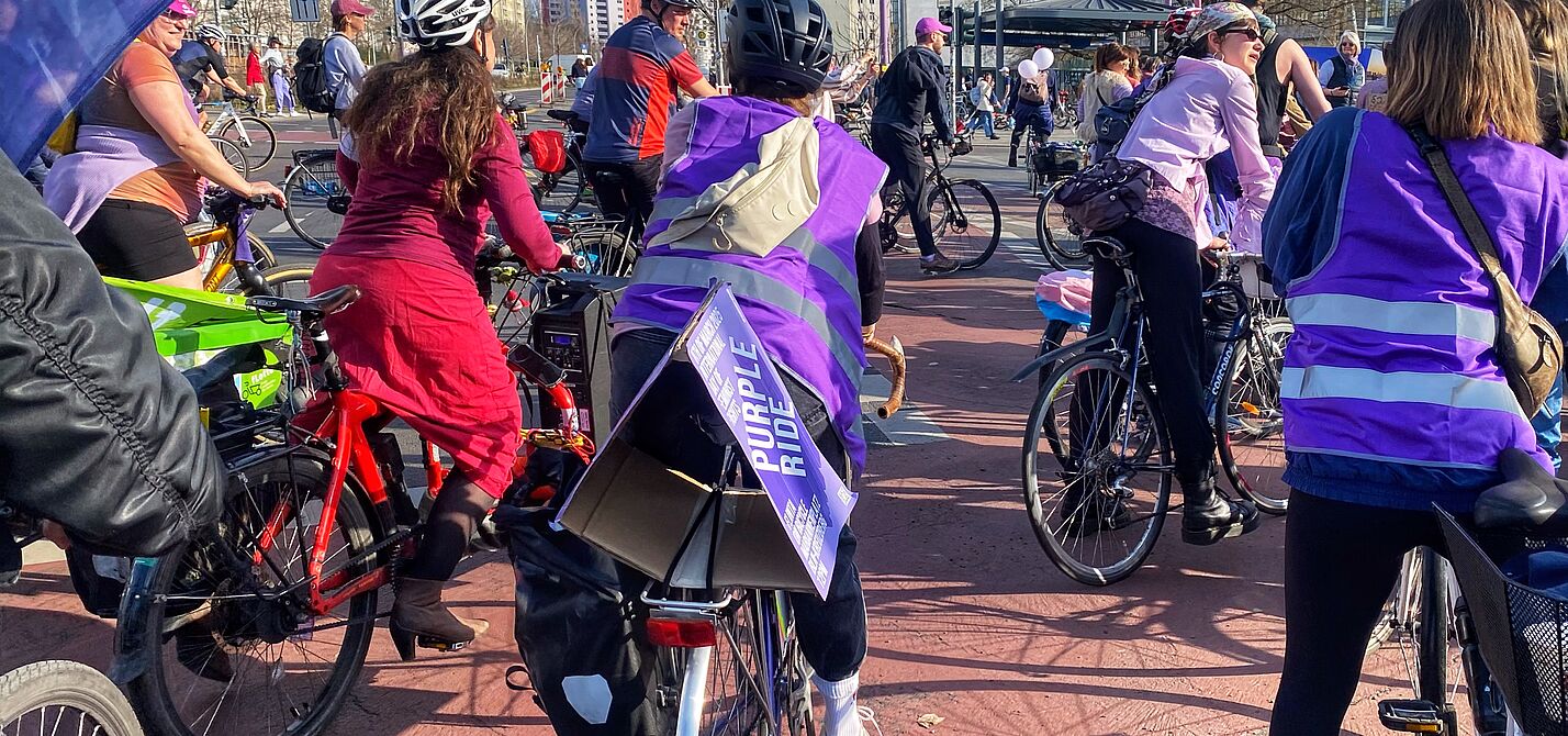 Beim Purple Ride am 08.03.2025 sind mehrere Teilnehmerinnen zu sehen, und auch eine Flagge des ADFC Berlin
