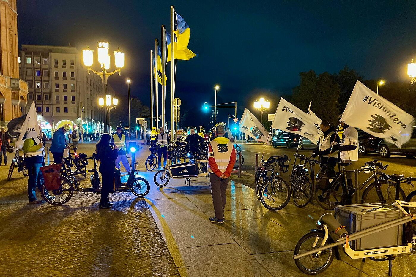 Geisterrad Kundgebung 9-11-2023 Menschen stehen mit Fahrrädern und weißen Vision Zero Fahnen vor dem Roten Rathaus bei einer Kundgebung