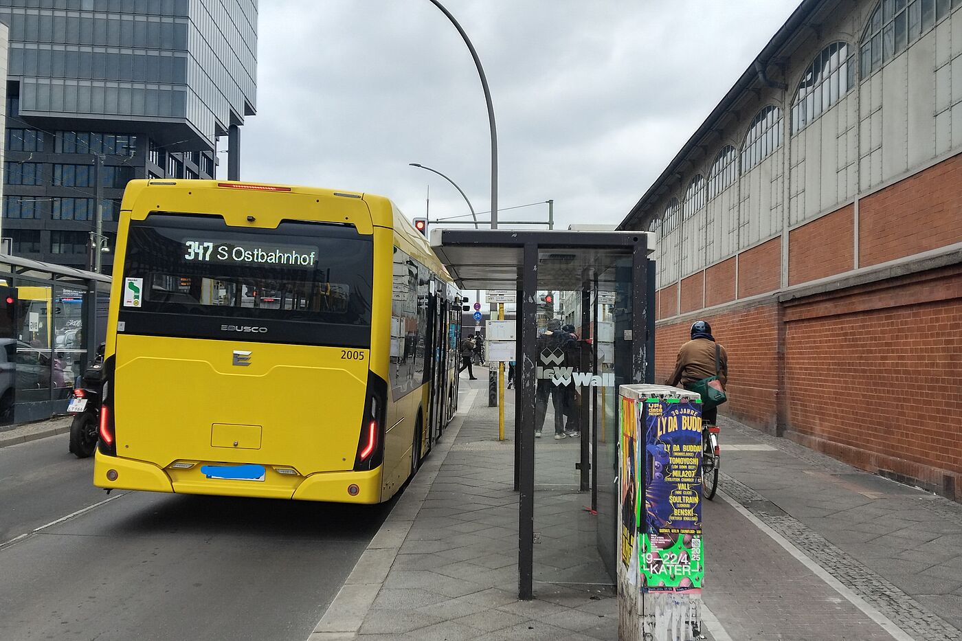 Bushaltestelle Warschauer Straße Ein Bus hält an einem Wartehäuschen. Der Radweg verläuft ohne Sicherheitsabstand direkt hinter dem Wartehäuschen