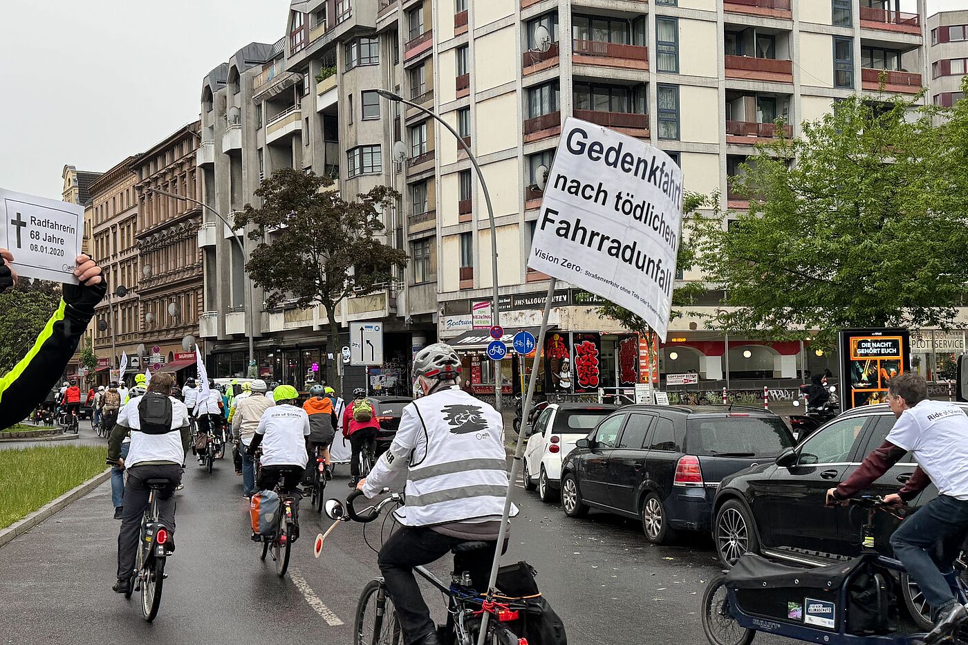 Ride of Silence 2026 Kottbusser Tor Mensch hält zum Gedenken an 2020 getötete Radfahrerin ein Schild bei Fahrraddemonstration in die Luft