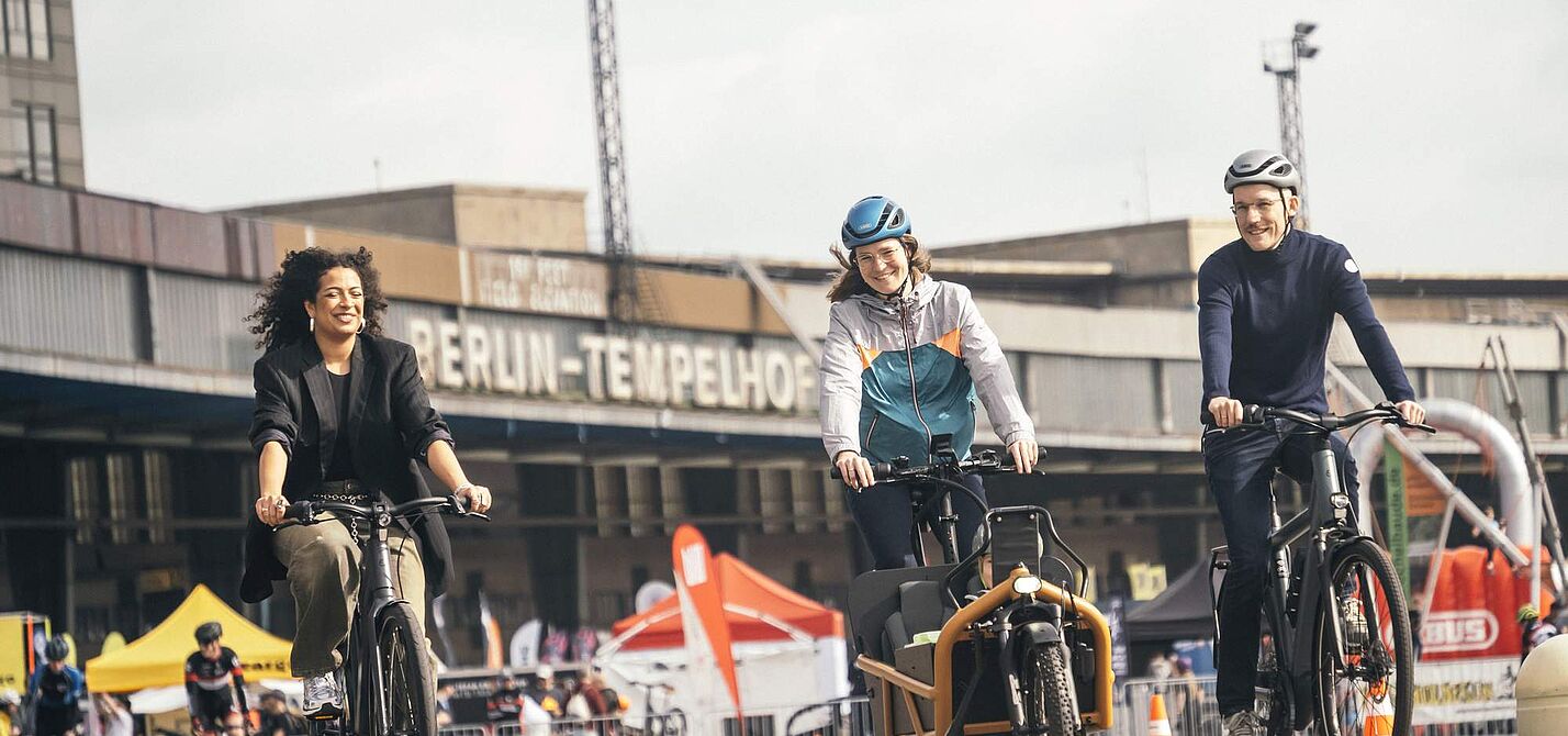 Menschen auf Fahrrädern vor dem Flughafen Tempelhof in Berlin