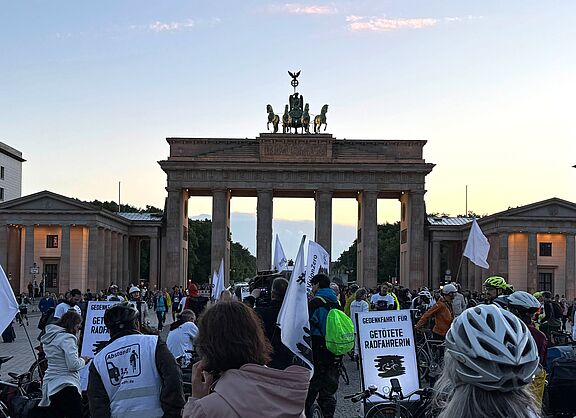 Radfahrende überwiegend in weiß gekleidet vor dem Brandenburger Tor