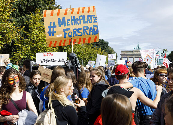 Aktiv im Frauen*Netzwerk Teilnehmende halten bei einer Demo ein Schild hoch.