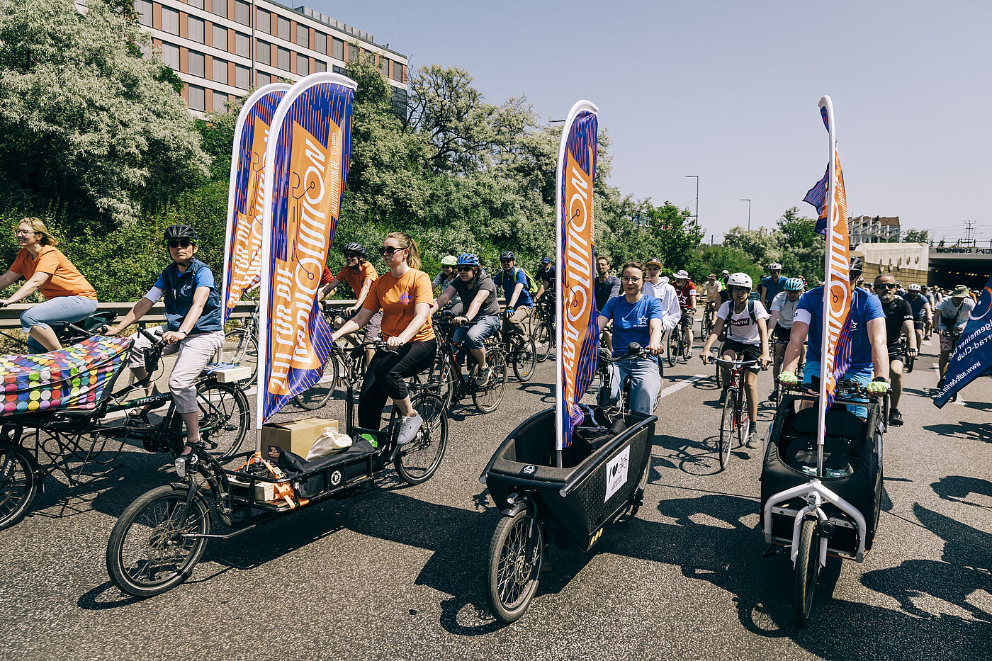 Sternfahrt 2023 Menschen fahren auf Lastenrädern mit Beachflags