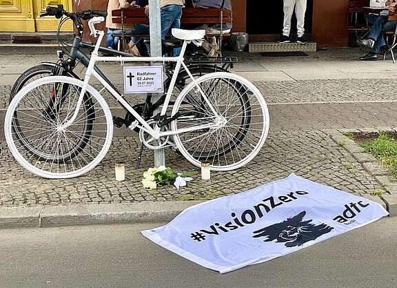 Geisterrad für den verstorbenen Radfahrer in Kreuzberg weißes Geisterrad mit Vision Zero Fahne