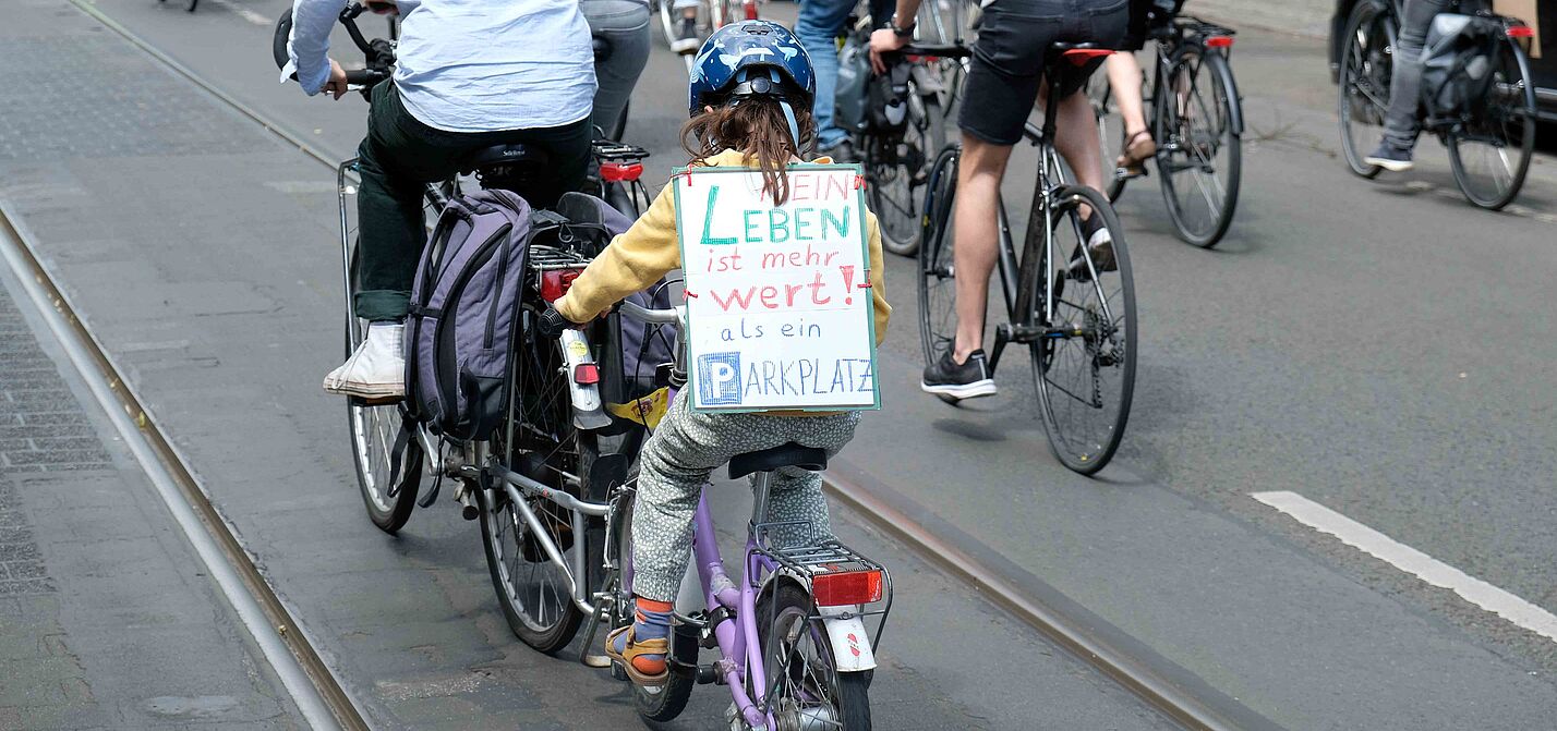 Mein Leben ist mehr wert als ein Parkplatz Demo nicht mit uns 2.6.23 Mädchen auf Fahrrad mit einem Schild auf dem steht: Mein Leben ist mehr wert als ein Parkplatz