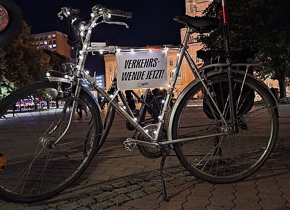 Lichterfahrt 2024 ein silbernes Fahrrad mit Lichterkette und Schild auf dem steht: Verkehrswende jetzt