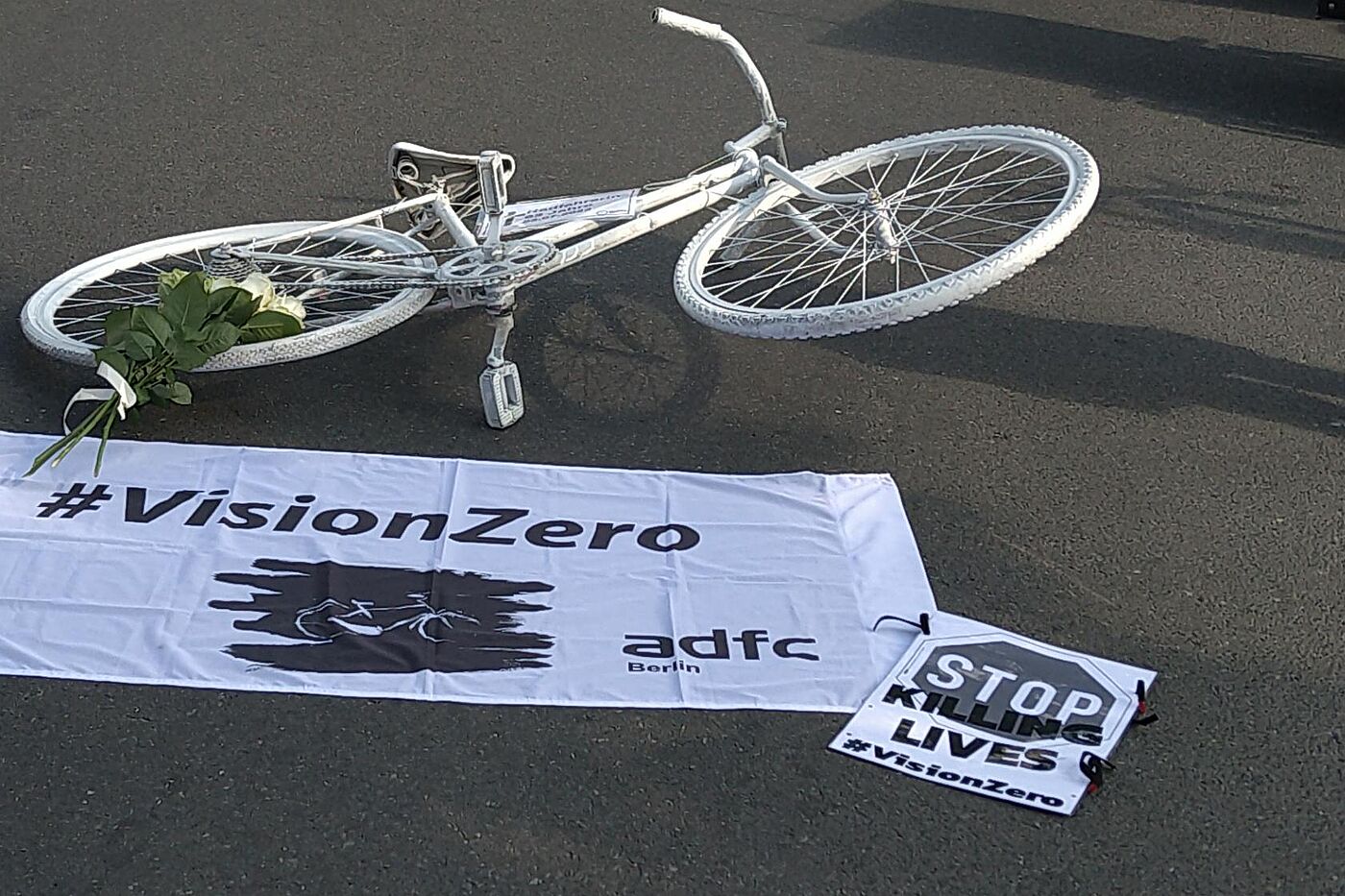 Vision Zero - das Ziel von null Verkehrstoten und null Schwerverletzten. weißes Fahrrad auf dem Boden, Vision Zero Banner darunter