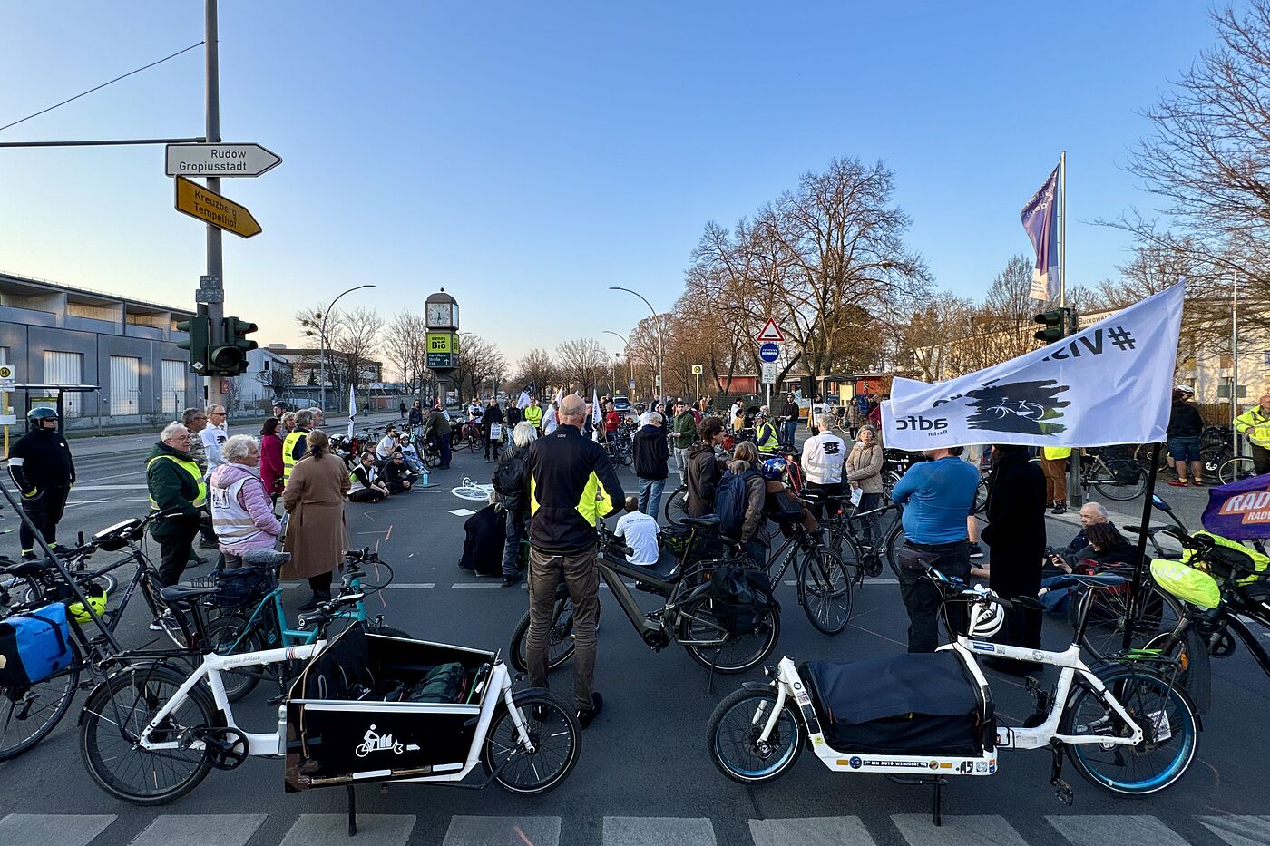 Mahnwache Buckower Damm Neukölln März 2025 Menschen stehen für eine Mahnwache auf der Straße, Vision Zero Fahne im Vordergrund