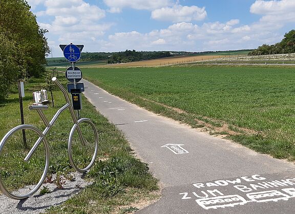 Radweg mit Fahrradkunstwerk am Wegesrand