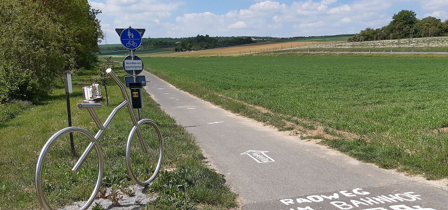 Radweg mit Fahrradkunstwerk am Wegesrand