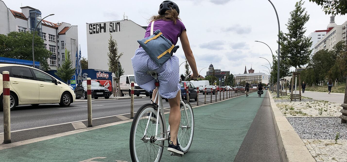 Frau auf geschütztem Radfahrstreifen
